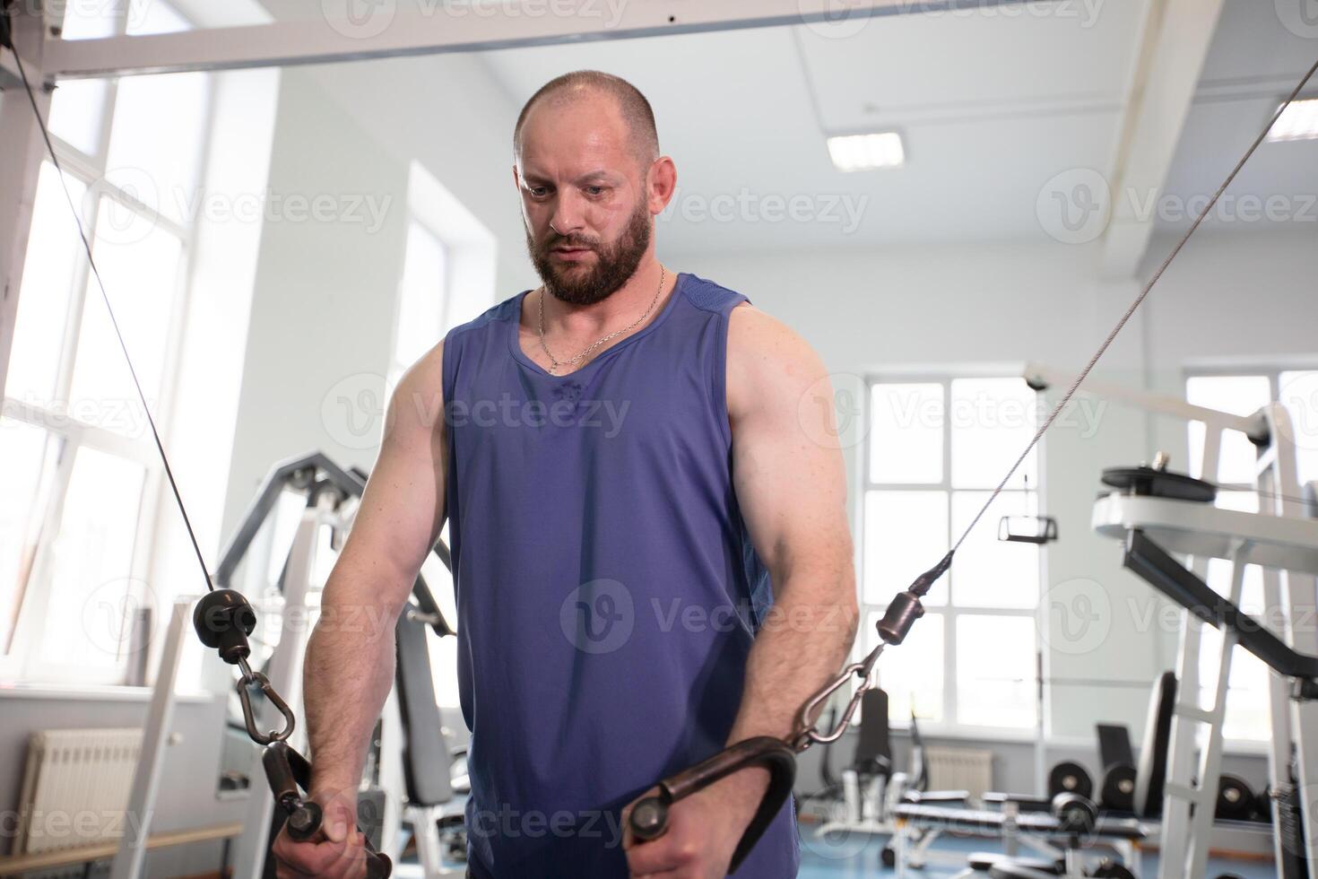 Male athlete bodybuilder exercising in the gym photo