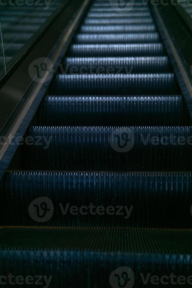 Escalator in a modern shopping center in dark tones photo