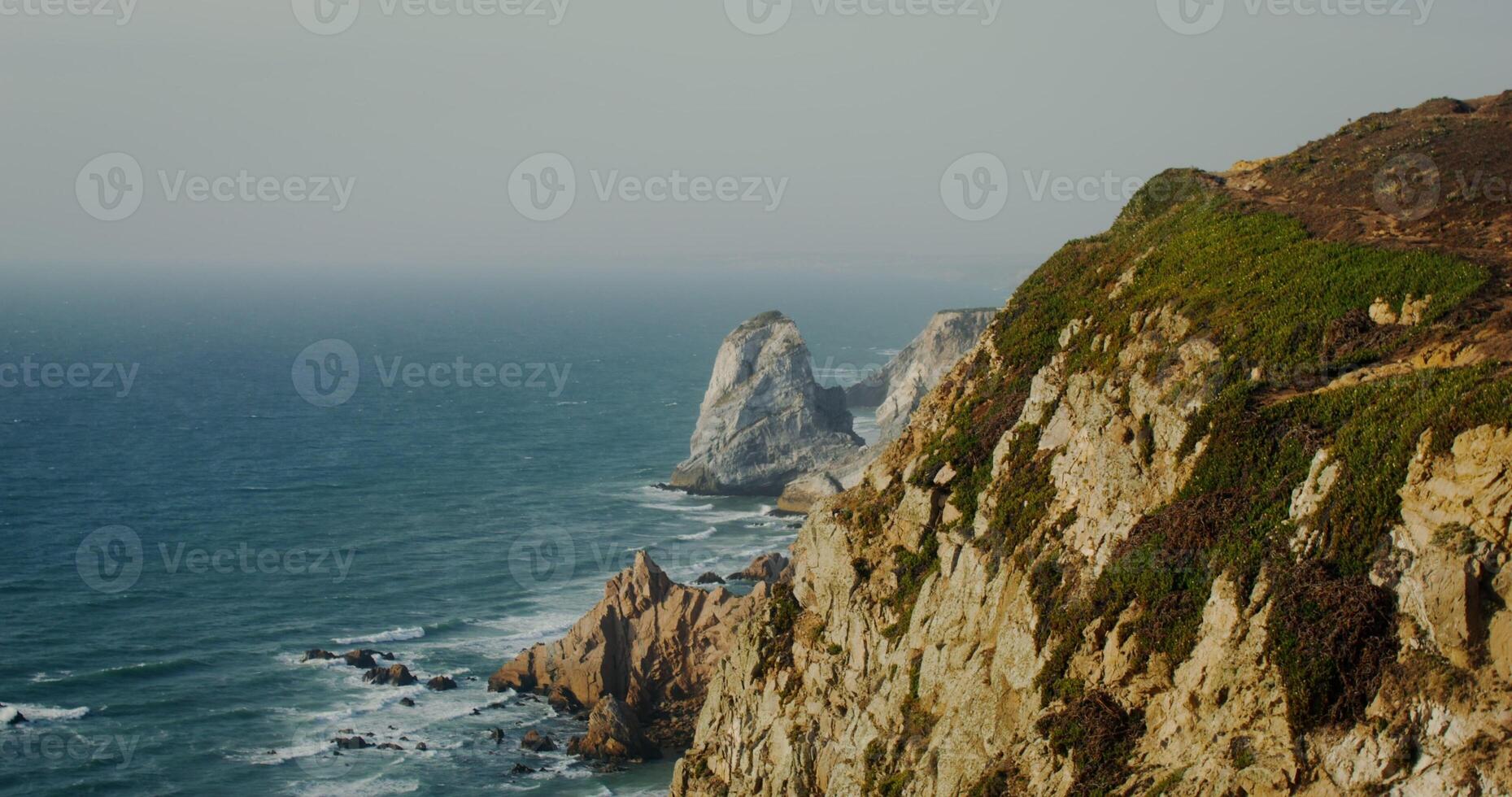 View top of the mountain to the seashore, sea waves beating against the rocks photo