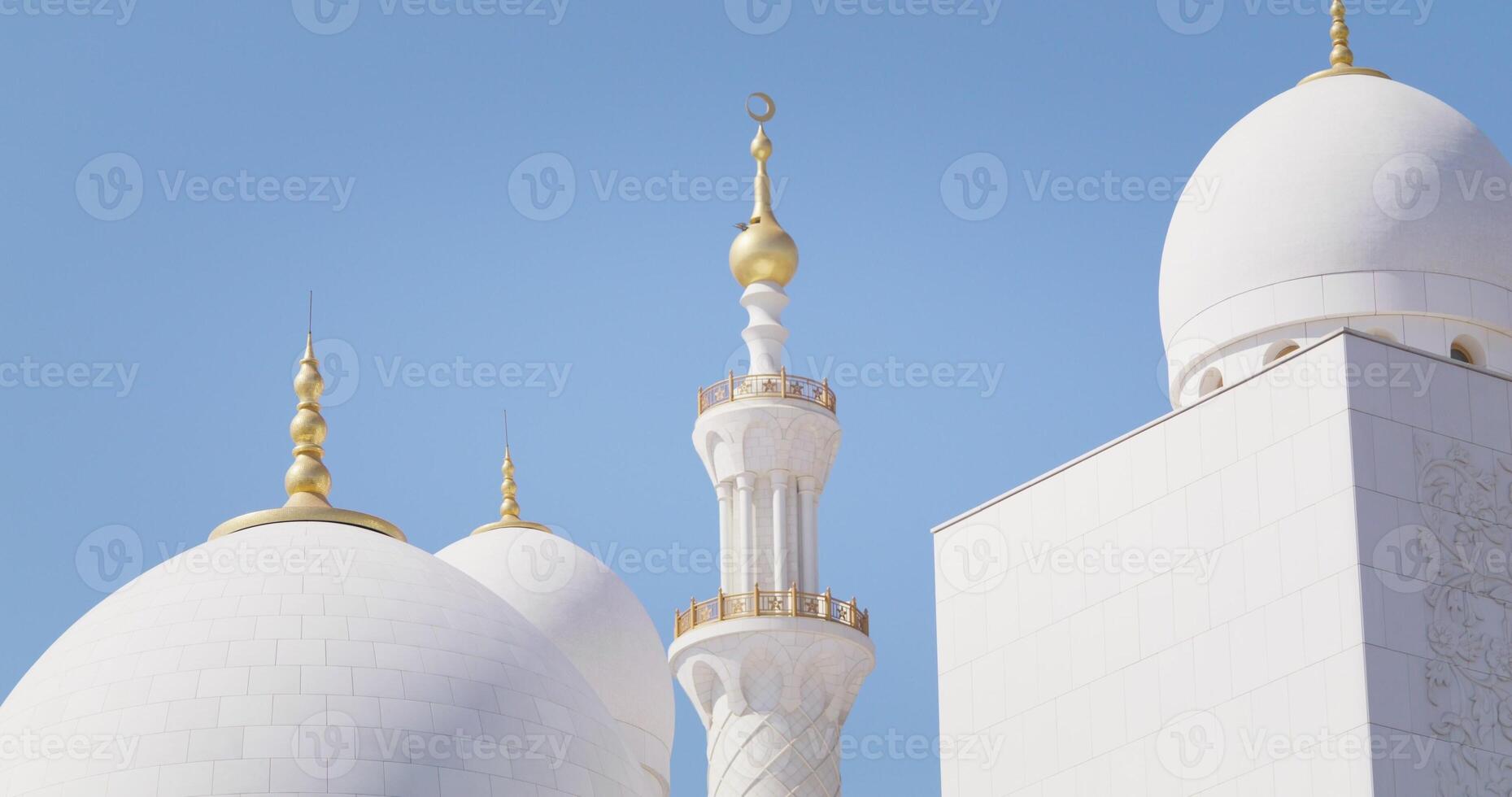 White domes of Abu Dhabi mosque against blue sky photo