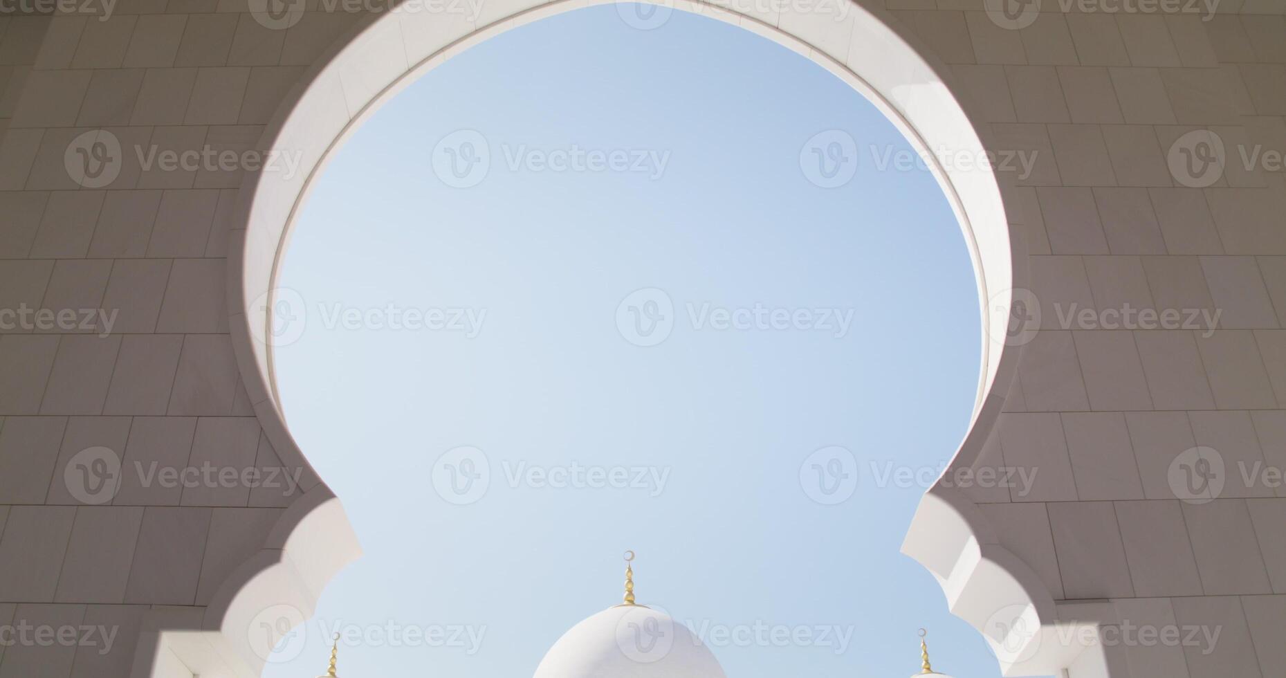 The facade of the mosque in Abu Dhabi, UAE, view through the arch photo