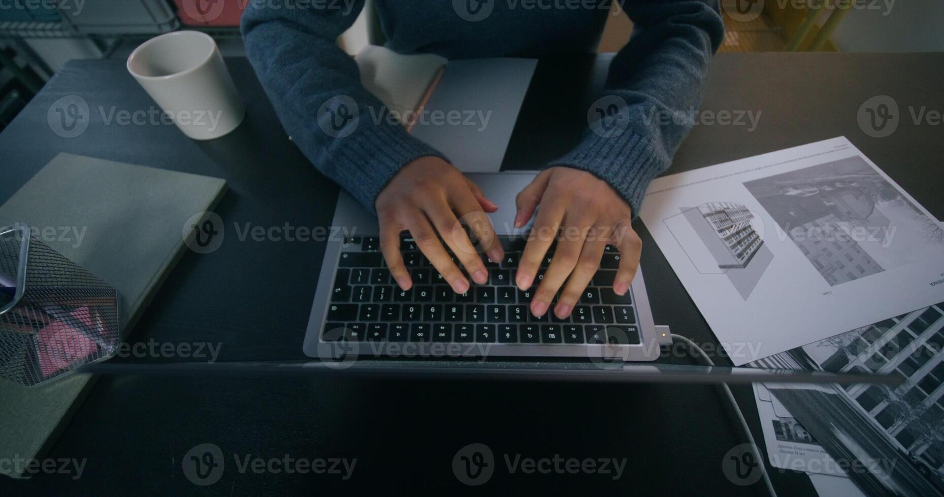 A woman is typing on a laptop, an unrecognizable person photo