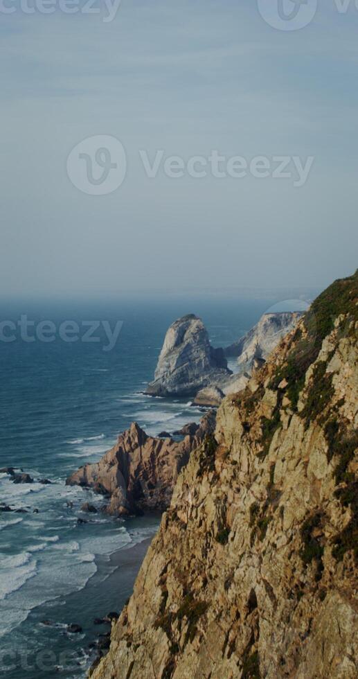 Sea view from high mountain. Sea waves beat against rocky ledges photo