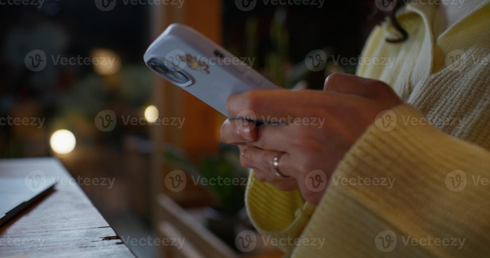 The woman is using a mobile phone, she is smiling. The moves from close-up of her hands to her face. Home interior photo