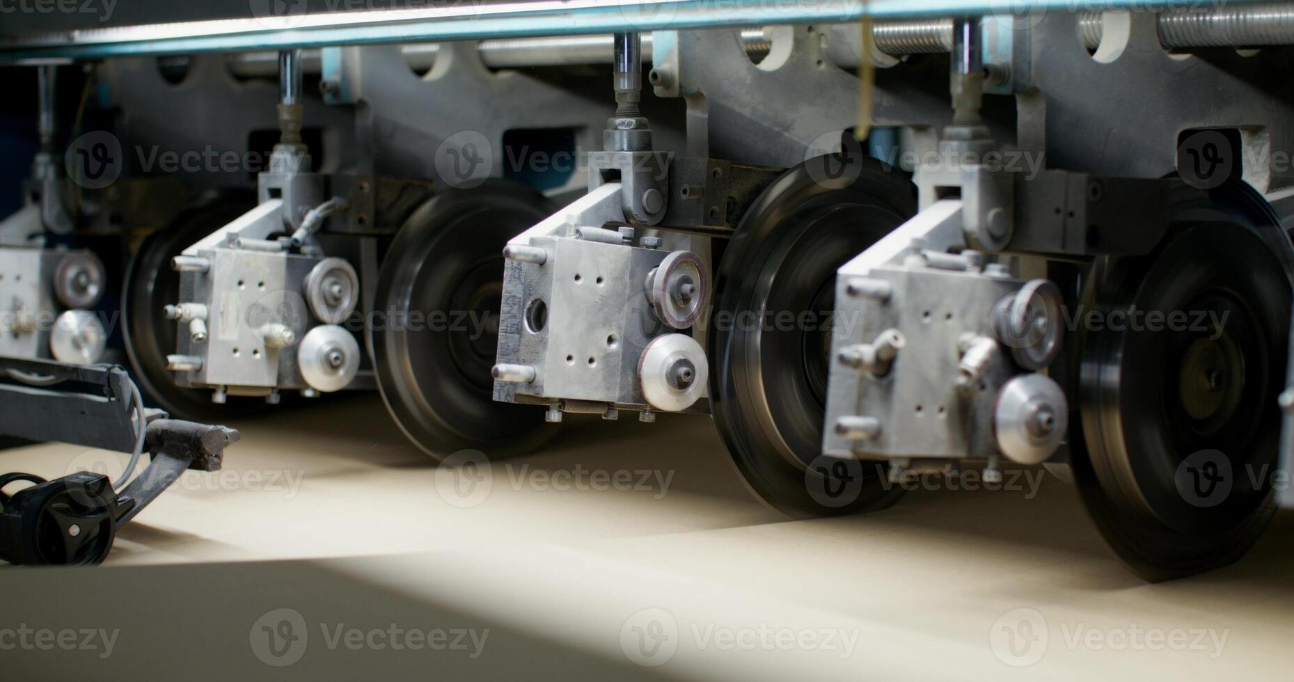 Production of cardboard. A close-up of the details of the machine for the production of cardboard in the factory. Cutting of cardboard sheets photo