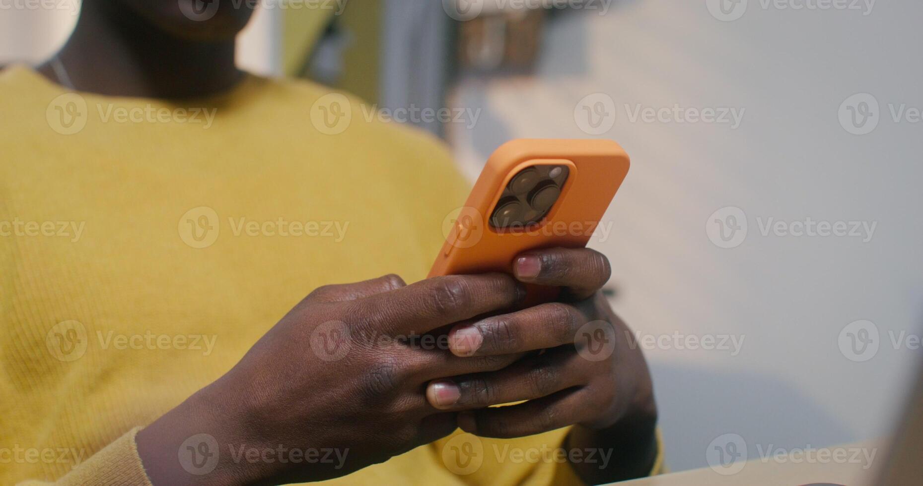 A man typing on a mobile phone sitting indoors photo