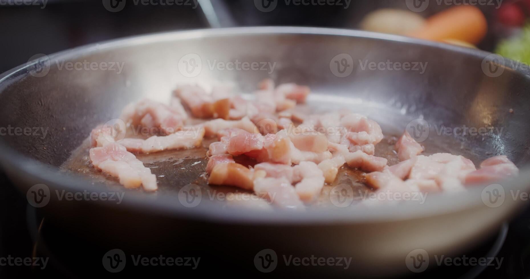 Bacon is fried in a frying pan photo
