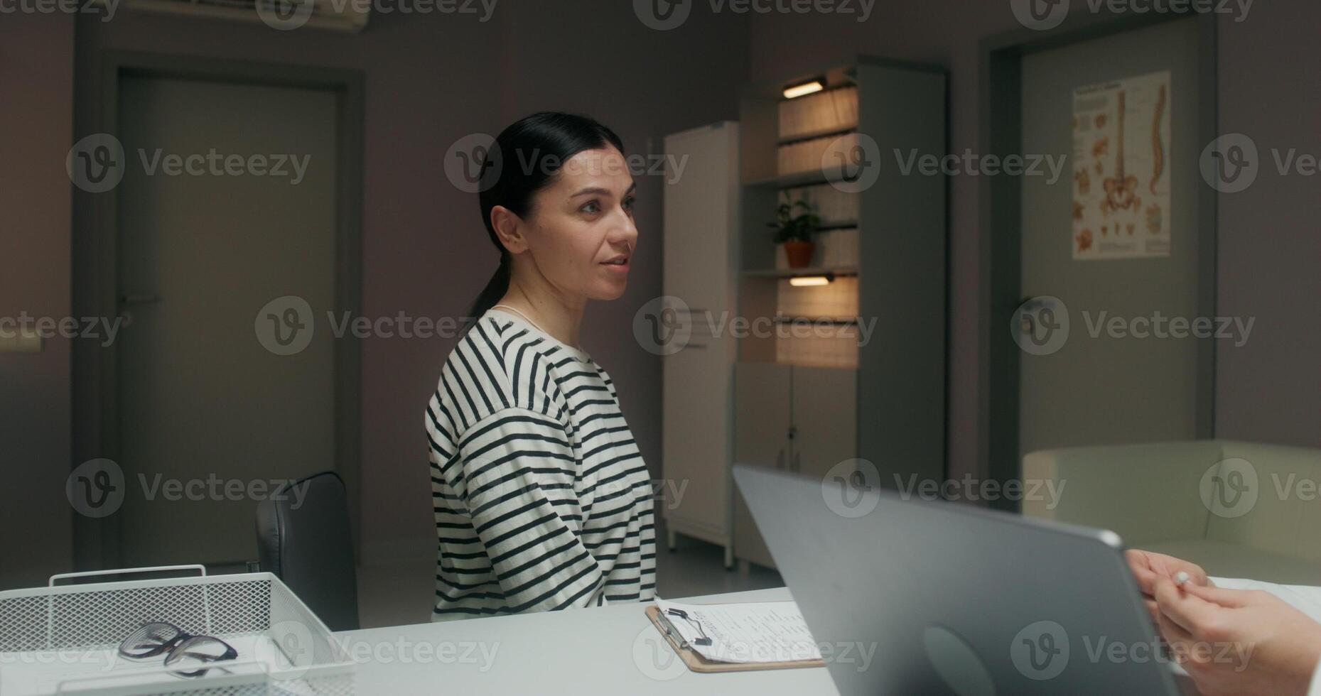 A woman talks about her illness sitting in a medical office and looking at a doctor. Medical appointment photo