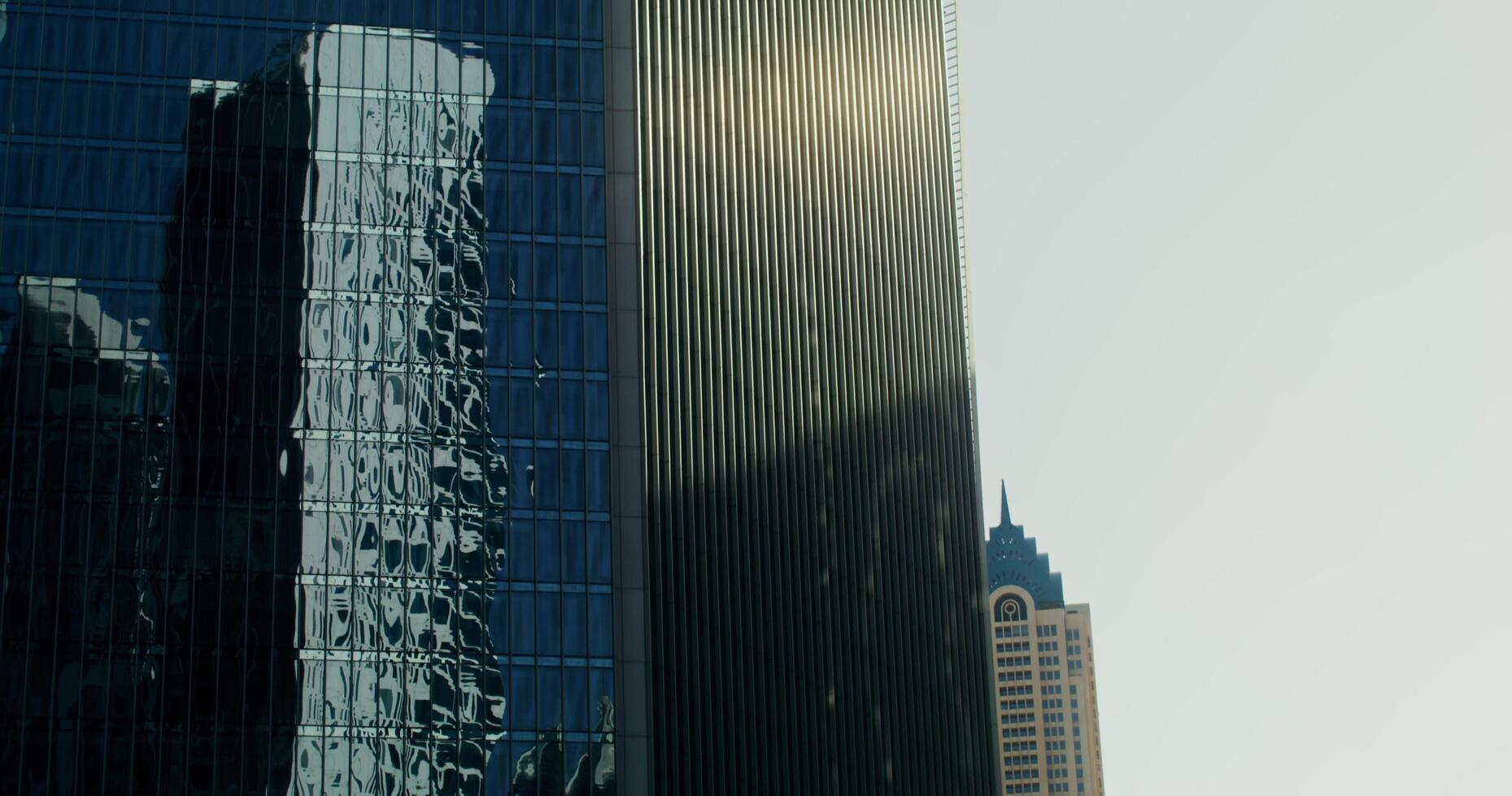 Dubai, UAE, 2025 - The glass facade of a modern skyscraper with other high-rise buildings reflected in the windows photo