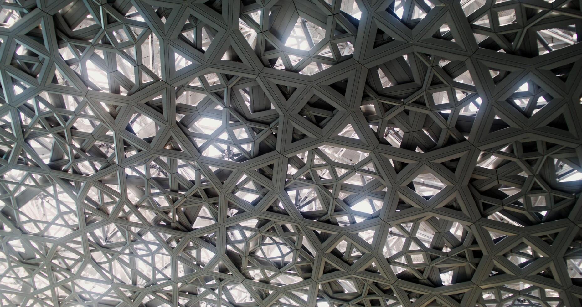 Abu Dhabi, UAE, 2025 - Close-up of the openwork dome of the Abu Dhabi Museum of Art in Dubai. The camera is spinning photo