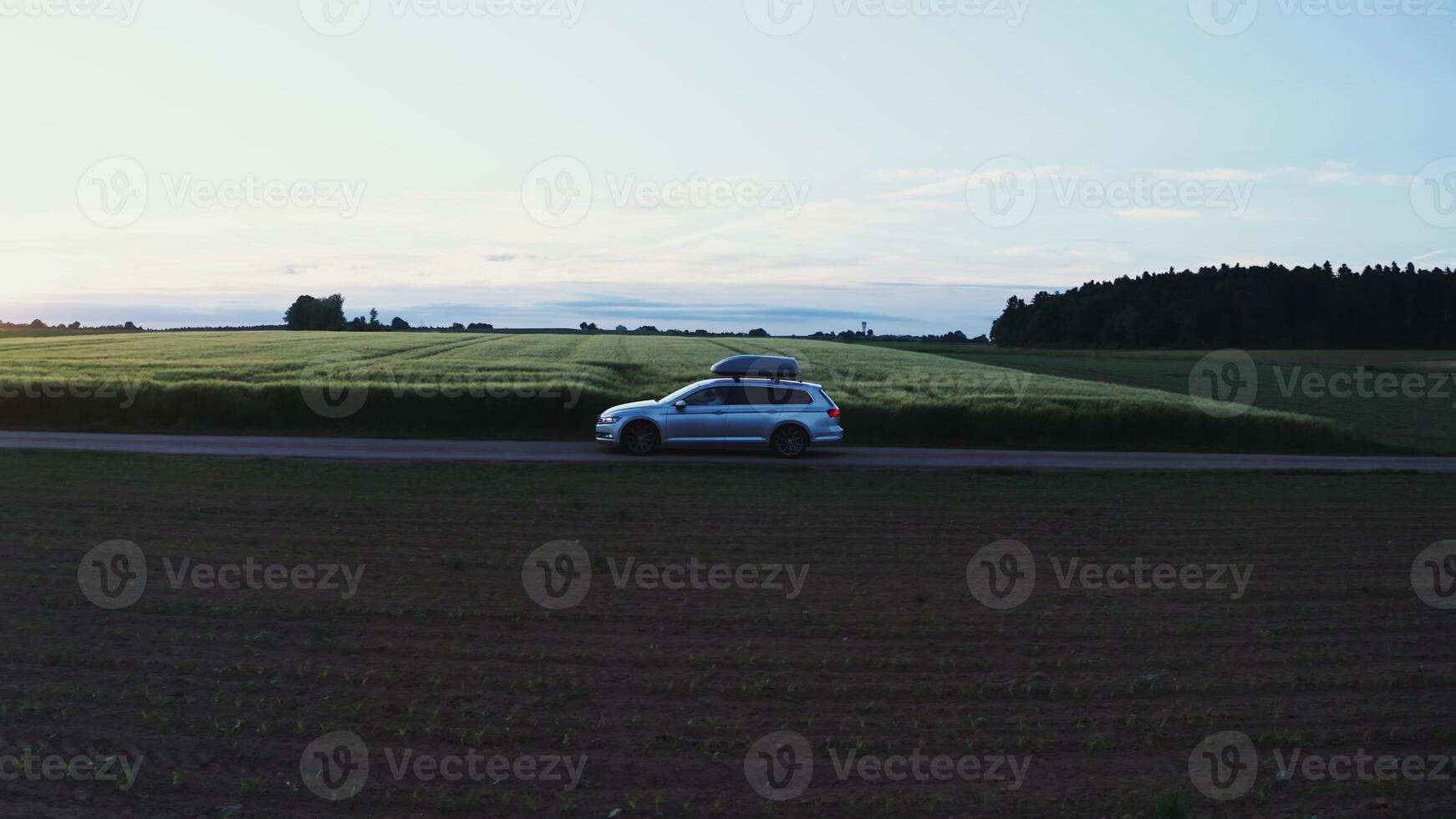 A car with a roof rack drives along the road photo