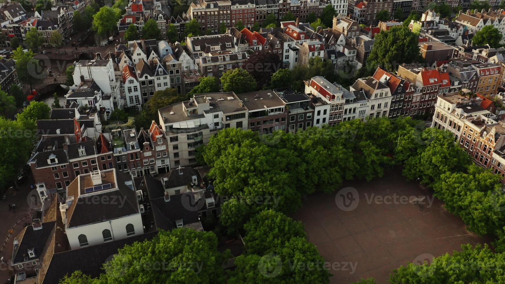 View of an old European city with traditional houses, narrow streets and a canal. Amsterdam, Netherlands, drone photo