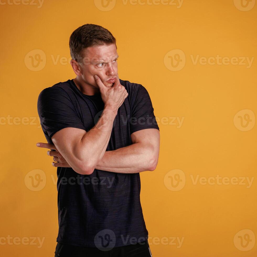 Hard thinking, looking to the side ,of, copy ,space. Man is against background in the studio, photo