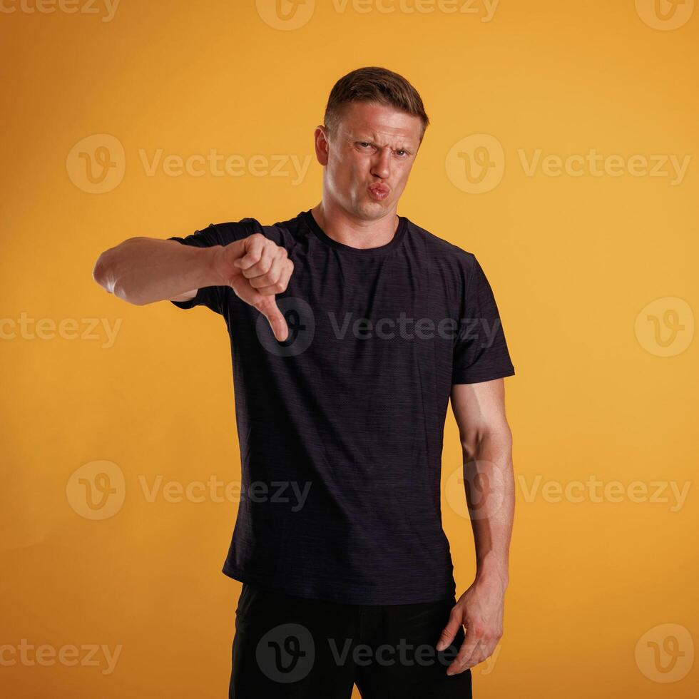 Unsatisfied, showing dislike. Man ,,is ,against, background in the studio photo