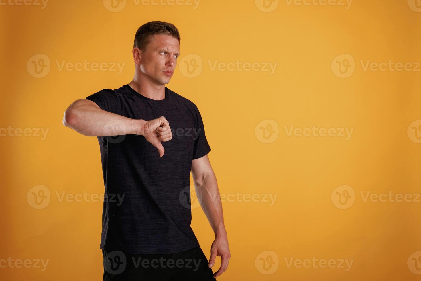 Unsatisfied,,, showing dislike. Man is against background in the studio photo