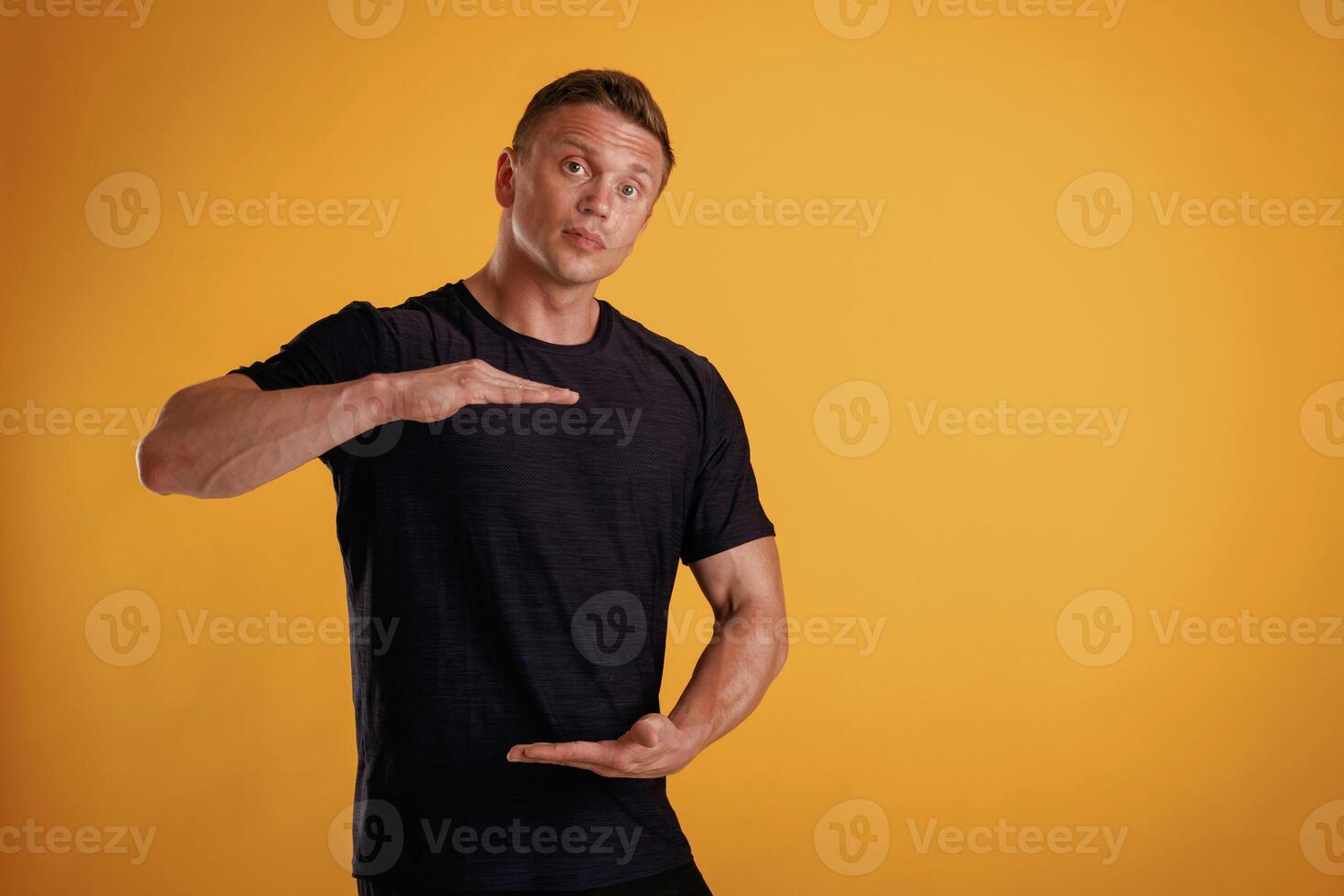 Holding, copy,, space invisible ,,banner ,in ,hands. Man is against background in the studio photo
