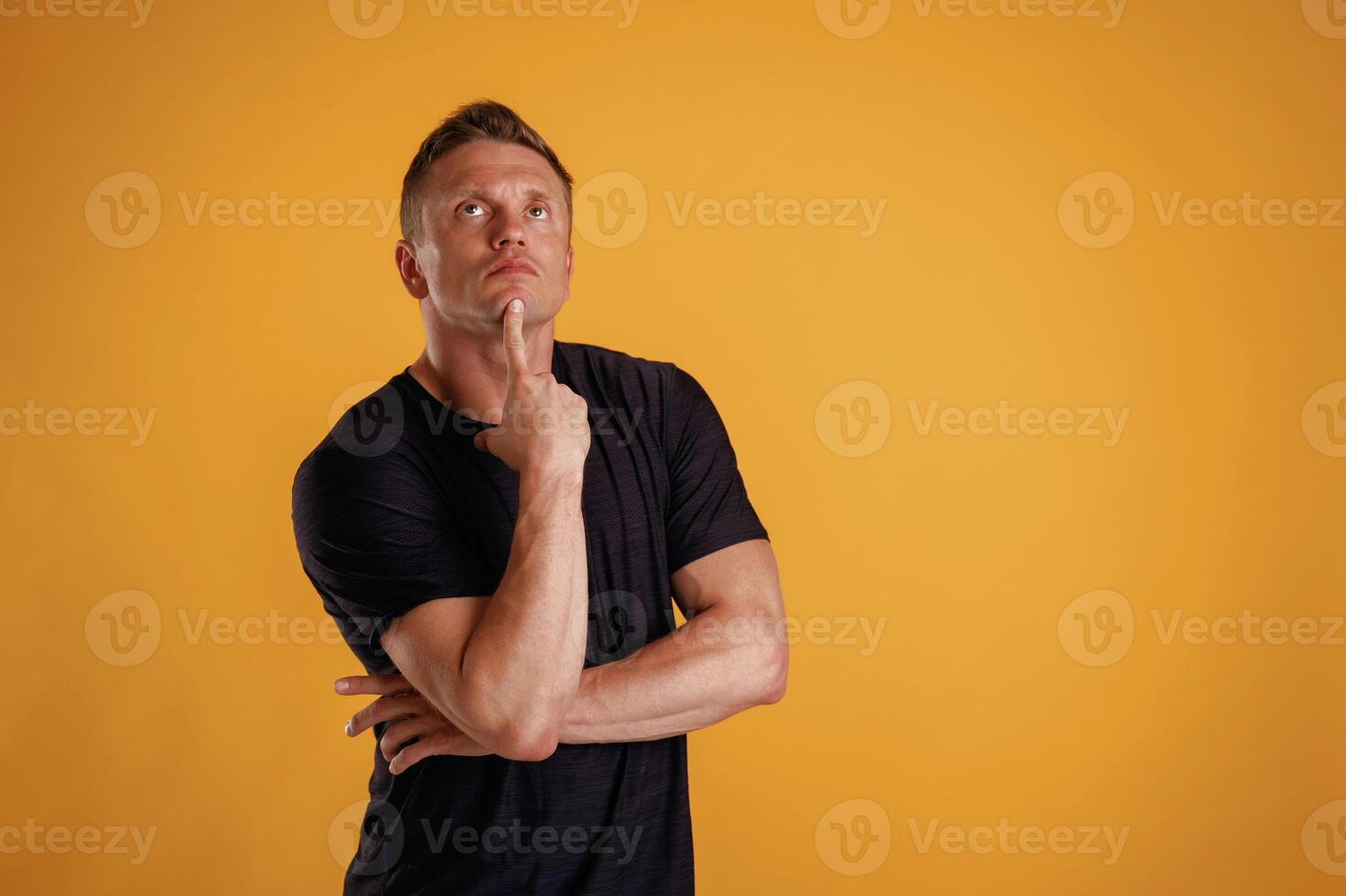 Smart, thinking and looking up. Man is against background in the studio photo