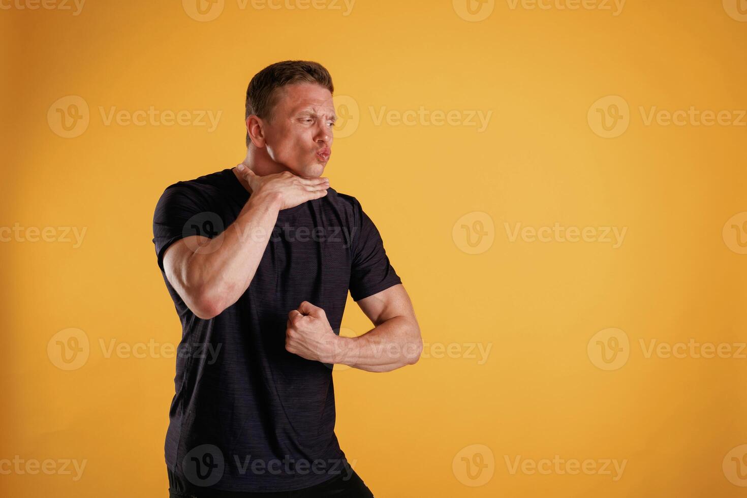 Struggle, showing muscles. Man is against background in the studio photo