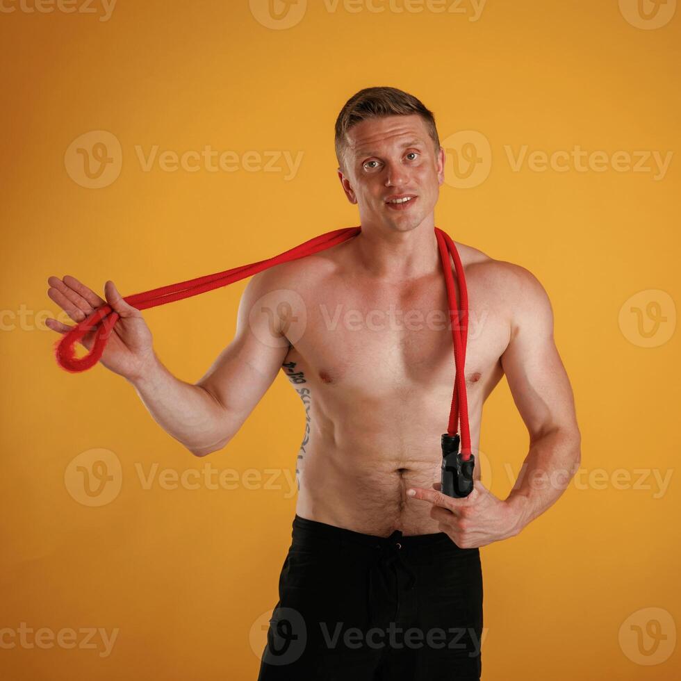 Red jump ropes, endurance, and, sport,, concept. Man is against background in the studio photo