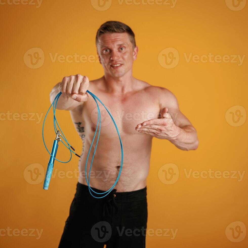 Blue ,jumping ,rope, fitness conception. Man is against background in the studio photo