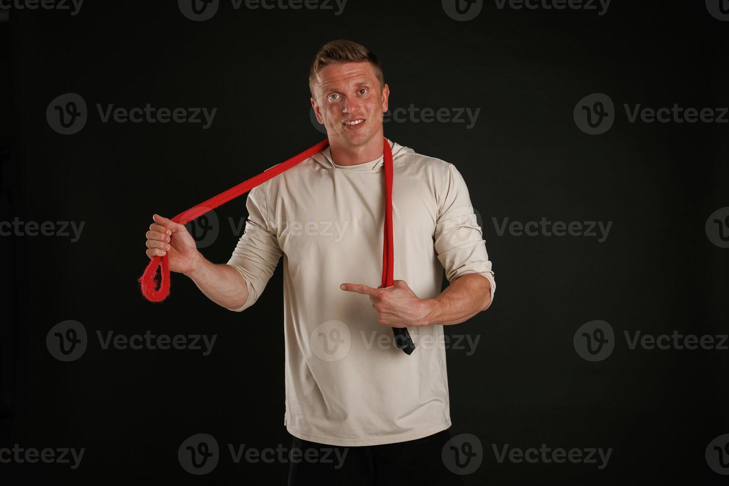 Red, jump ropes, endurance and sport concept. Man is against background in the studio photo