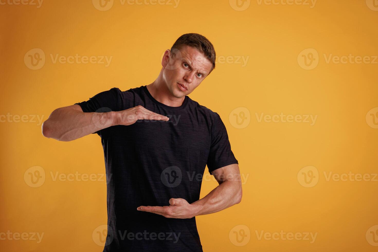 Holding ,copy, space invisible banner in hands. Man is against background in the studio photo