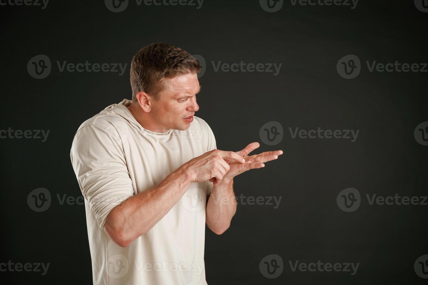 Take a look at this, copy space, showing on the palm of hand. Man is against background in the studio photo