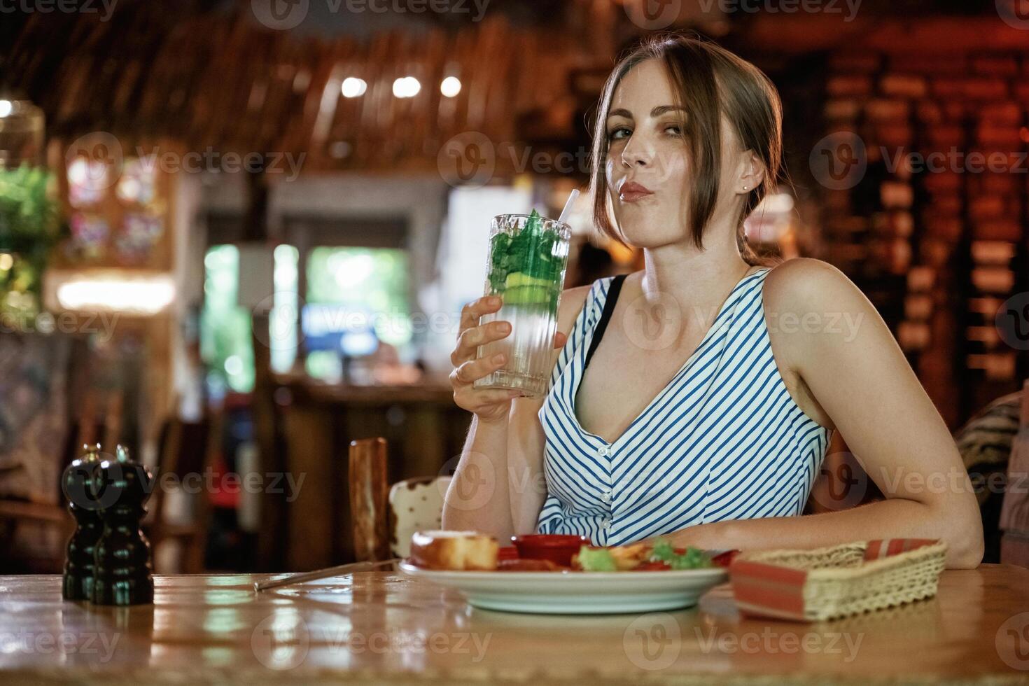 Fresh mojito is in hand..., Woman is in the restaurant with food and drink photo