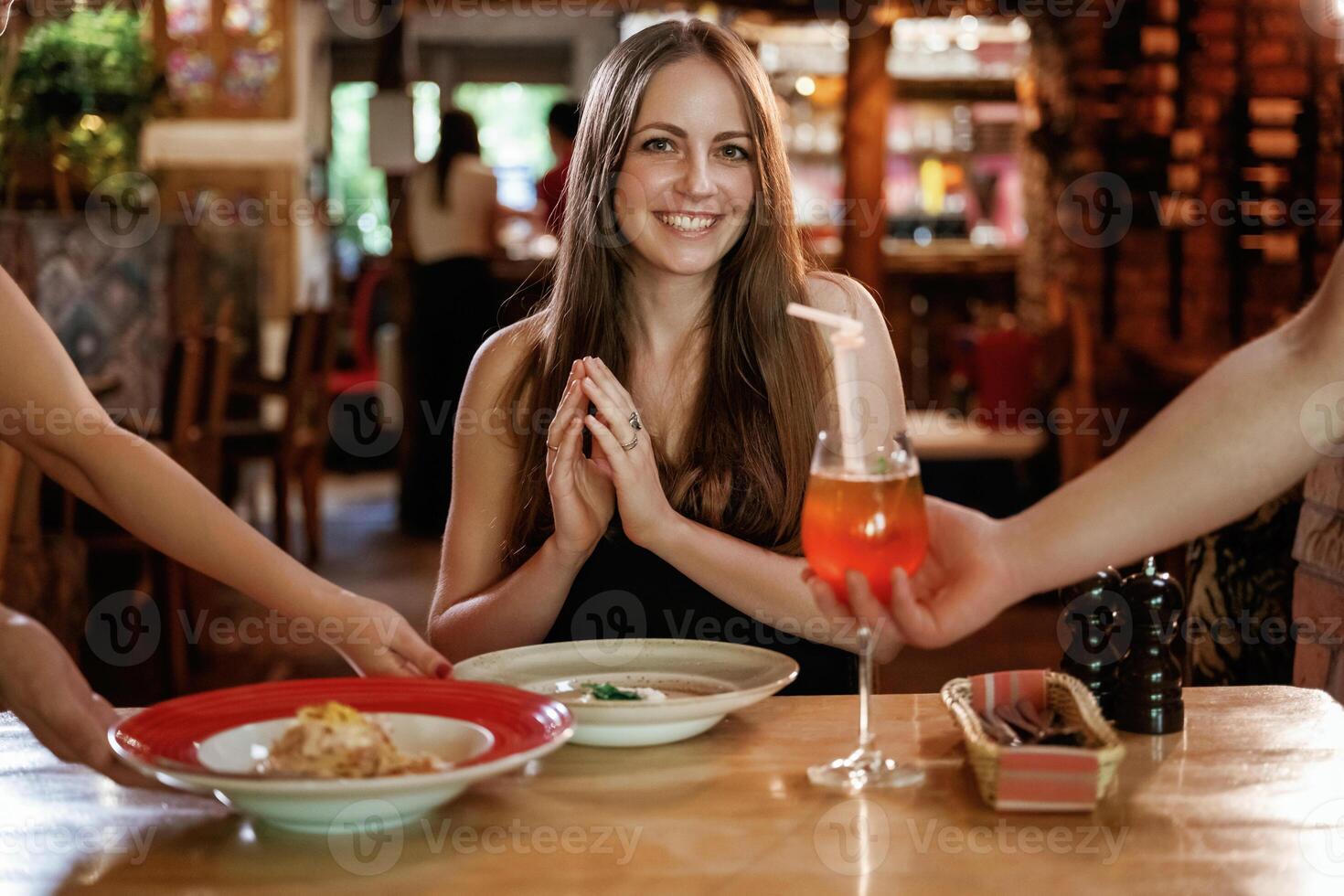 The ,waiters ,brought the food. Woman is in the restaurant photo