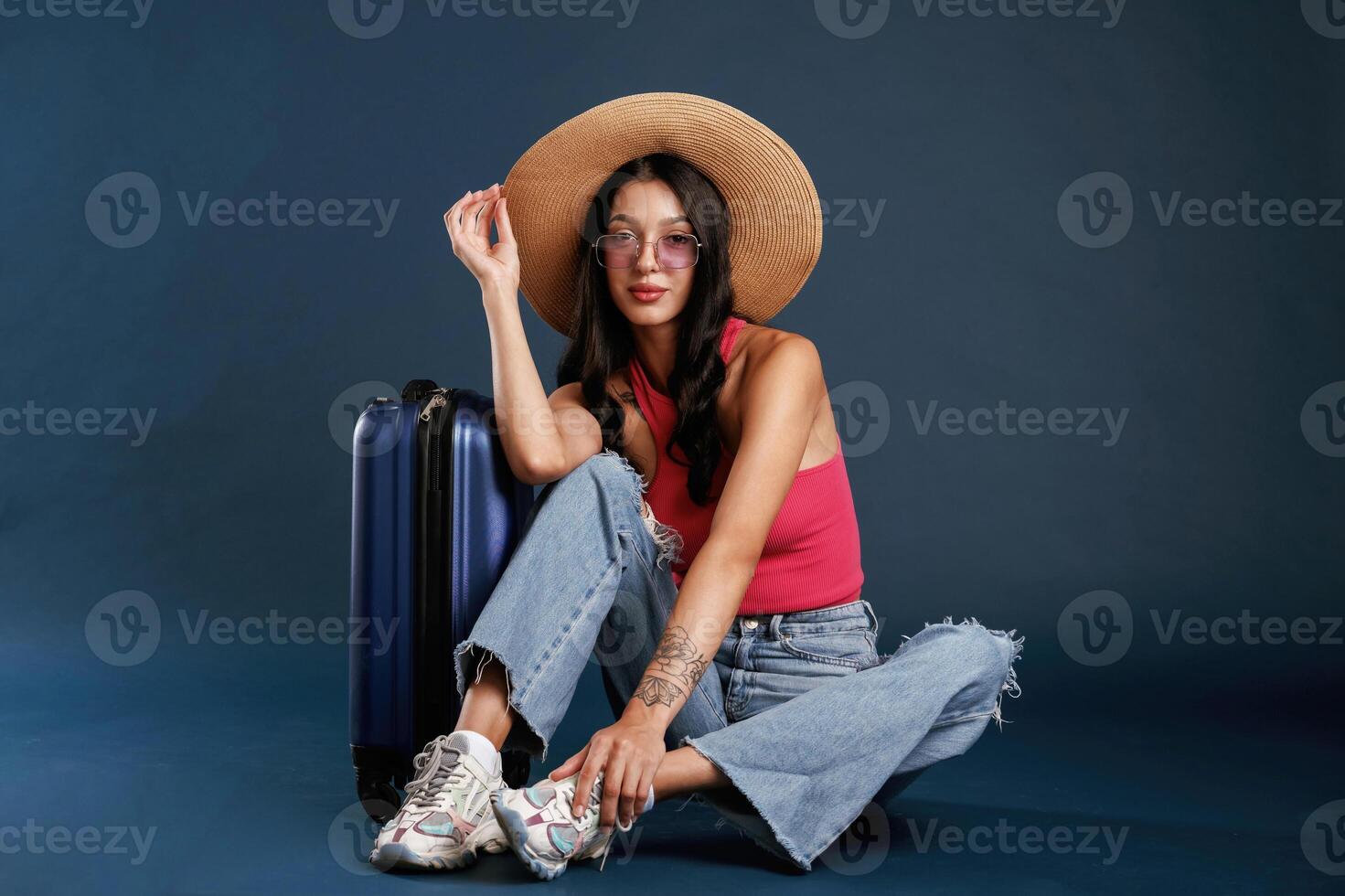 Vacation time, sitting ,with, suitcase. Beautiful young woman is against background photo