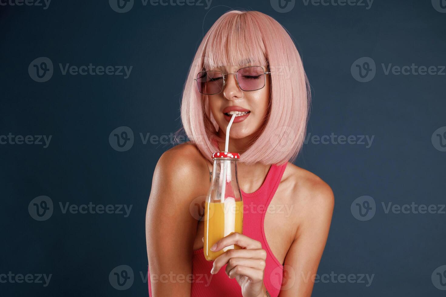 Pink, hair,, with orange juice. Beautiful young woman is against background photo