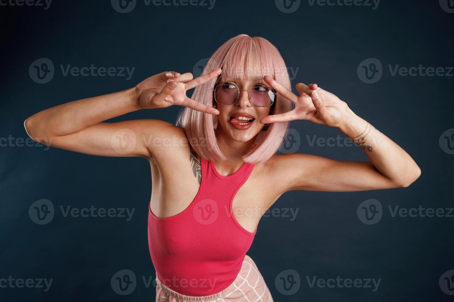 Happy hands, and fingers gesture, cute pink hair. Beautiful young woman is against background photo