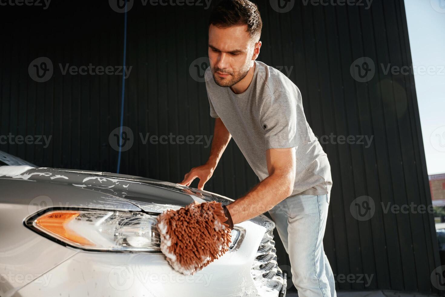 Focused at washing the automobile. Man is with his car outdoors photo