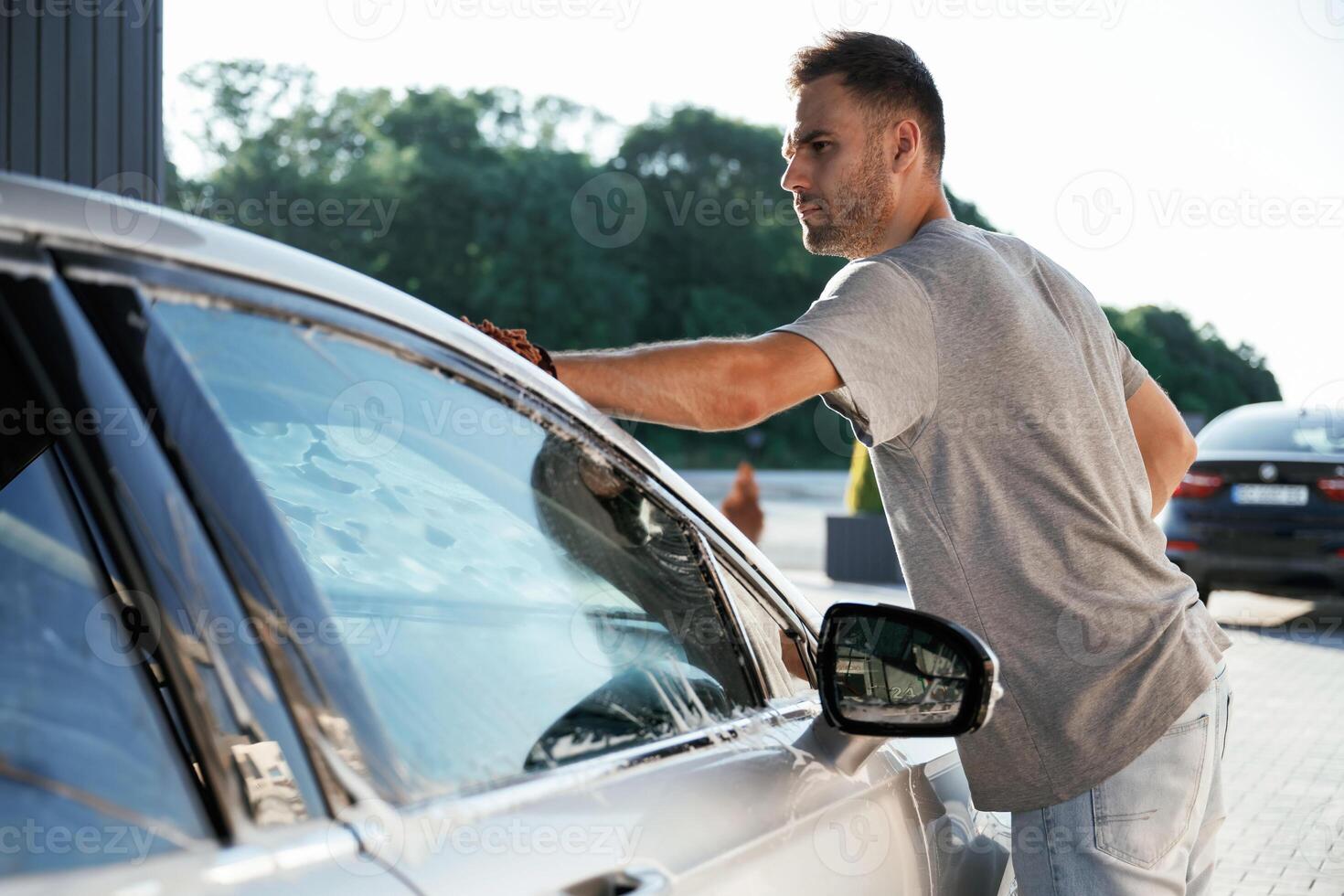 Transport is being cleaned., Washing service. Man is with his car outdoors photo