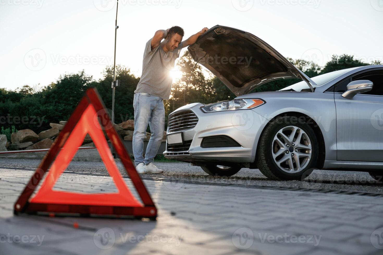 Unfortunate, transport is broken, red sign. Man is with his car outdoors photo