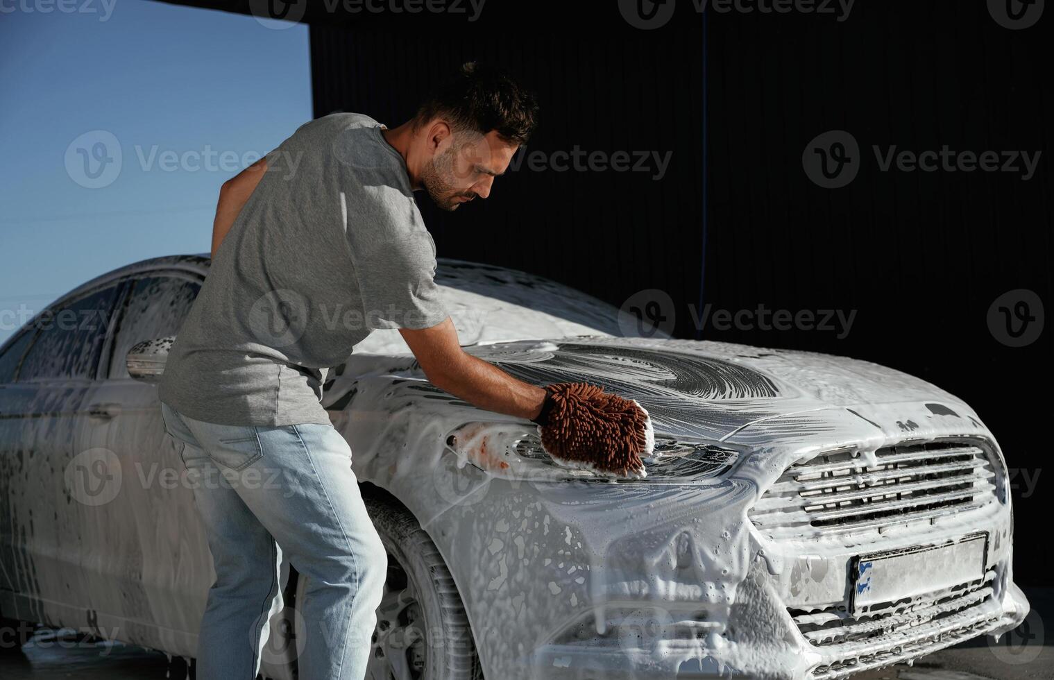 White soap and foam, washing, the,, automobile. Man is with his car outdoors photo