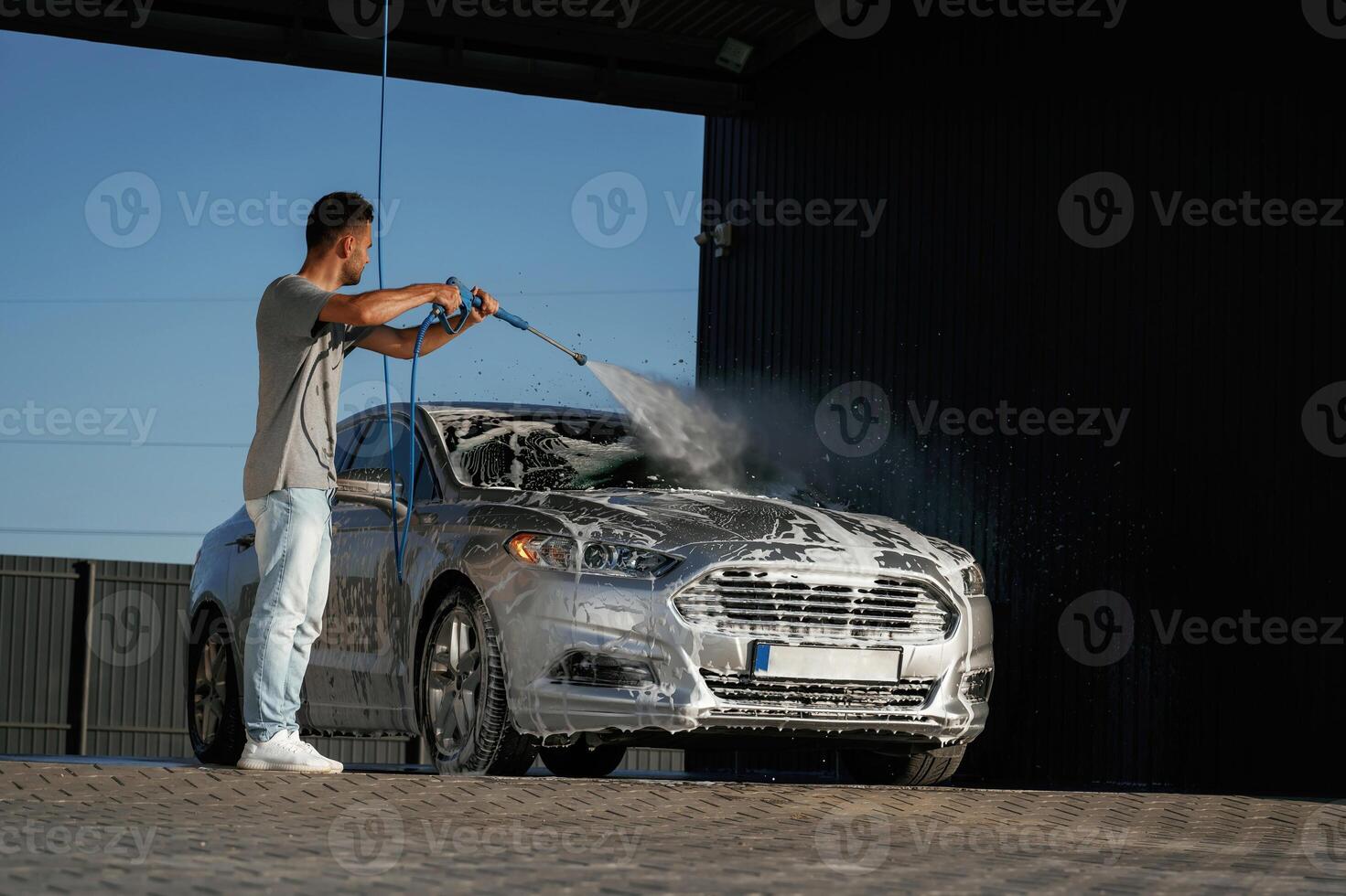 Foam, is ,being,, washed, automobile is in soap. Man is with his car outdoors photo