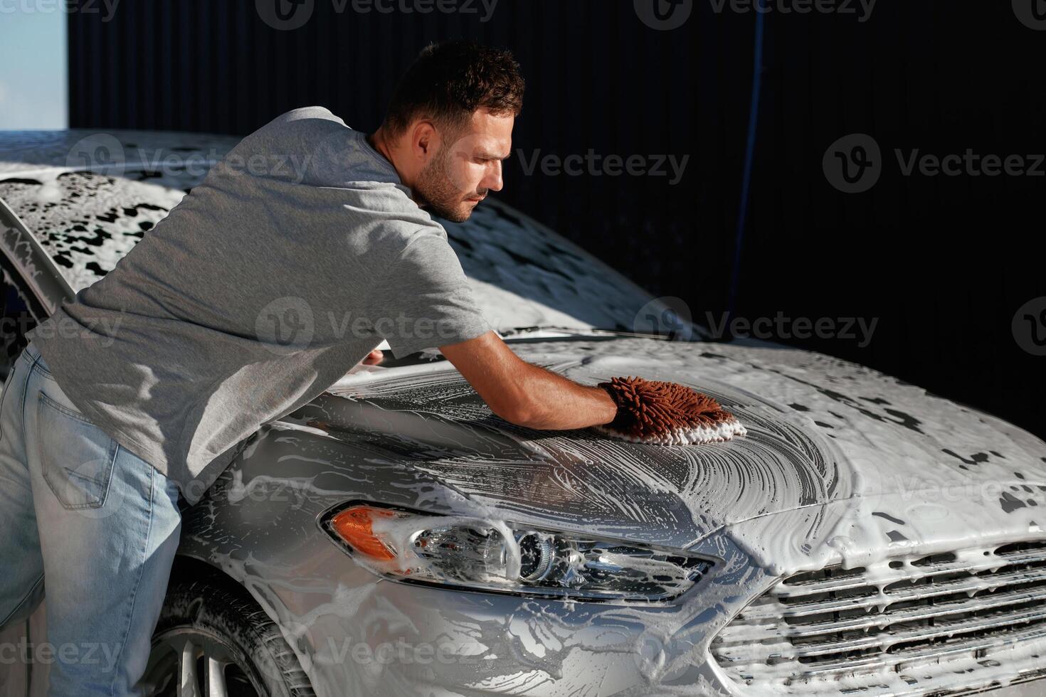 Process of washing the automobile. Man ,,is with his car outdoors photo