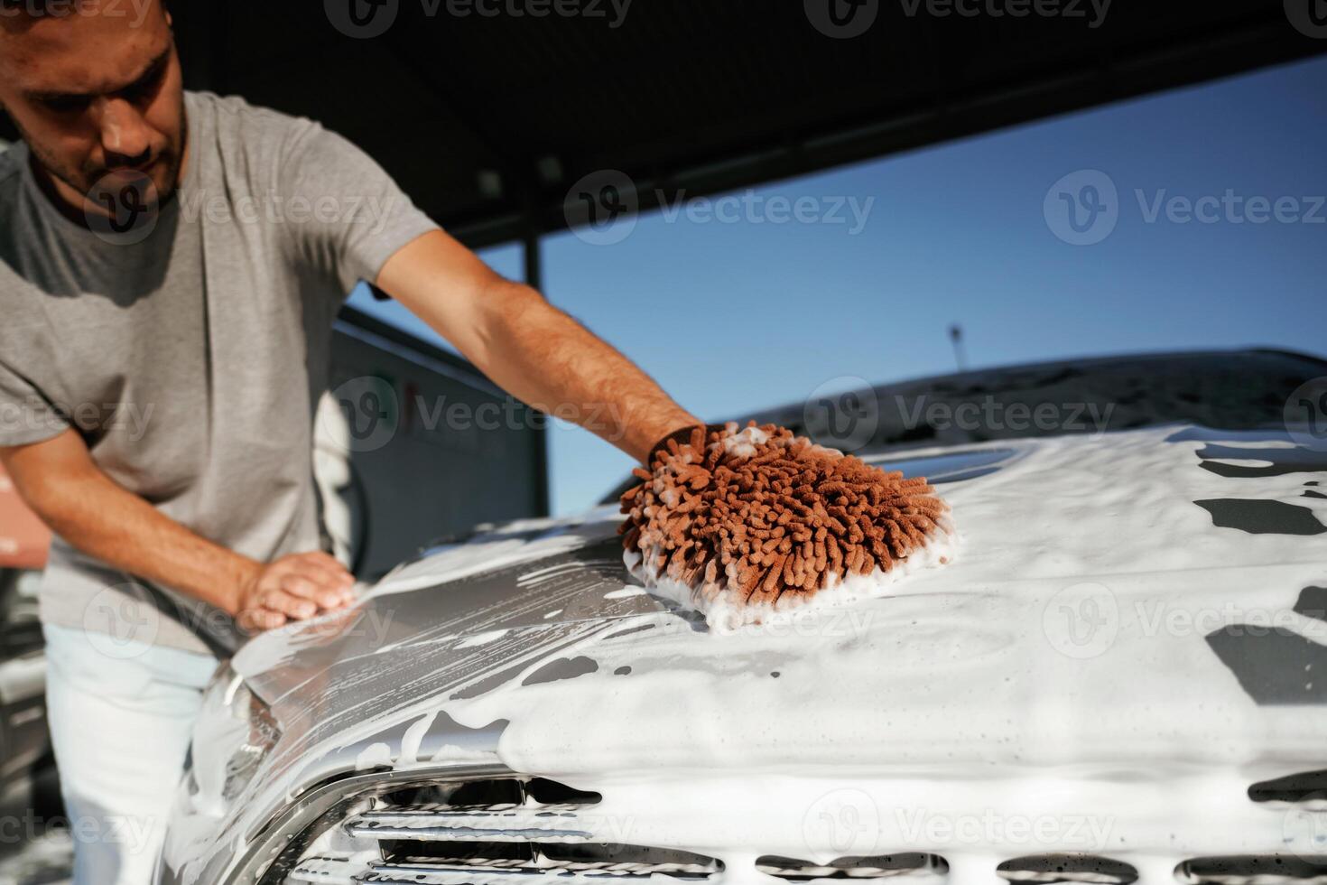 White, cleaning ,chemical, washing the automobile. Man is with his car outdoors photo