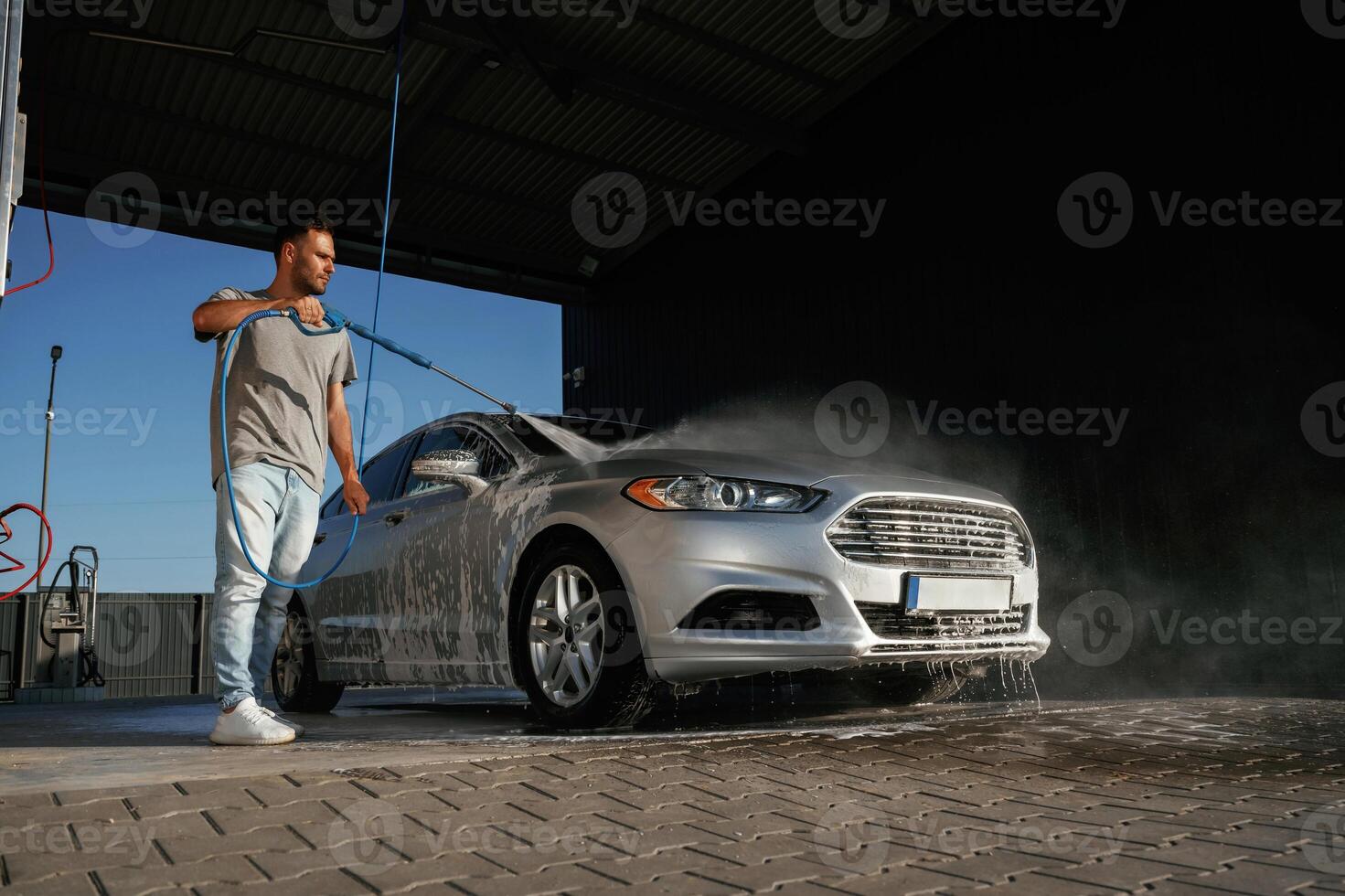 Silver, colored ,surface, washing the automobile. Man is with his car outdoors photo