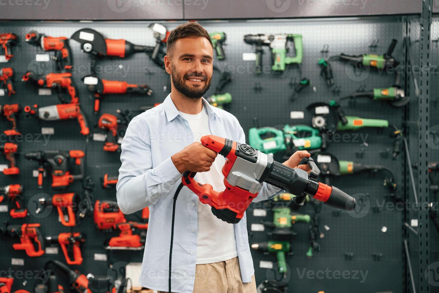 Plural perforator in hands. ..Man is in the hardware shop photo