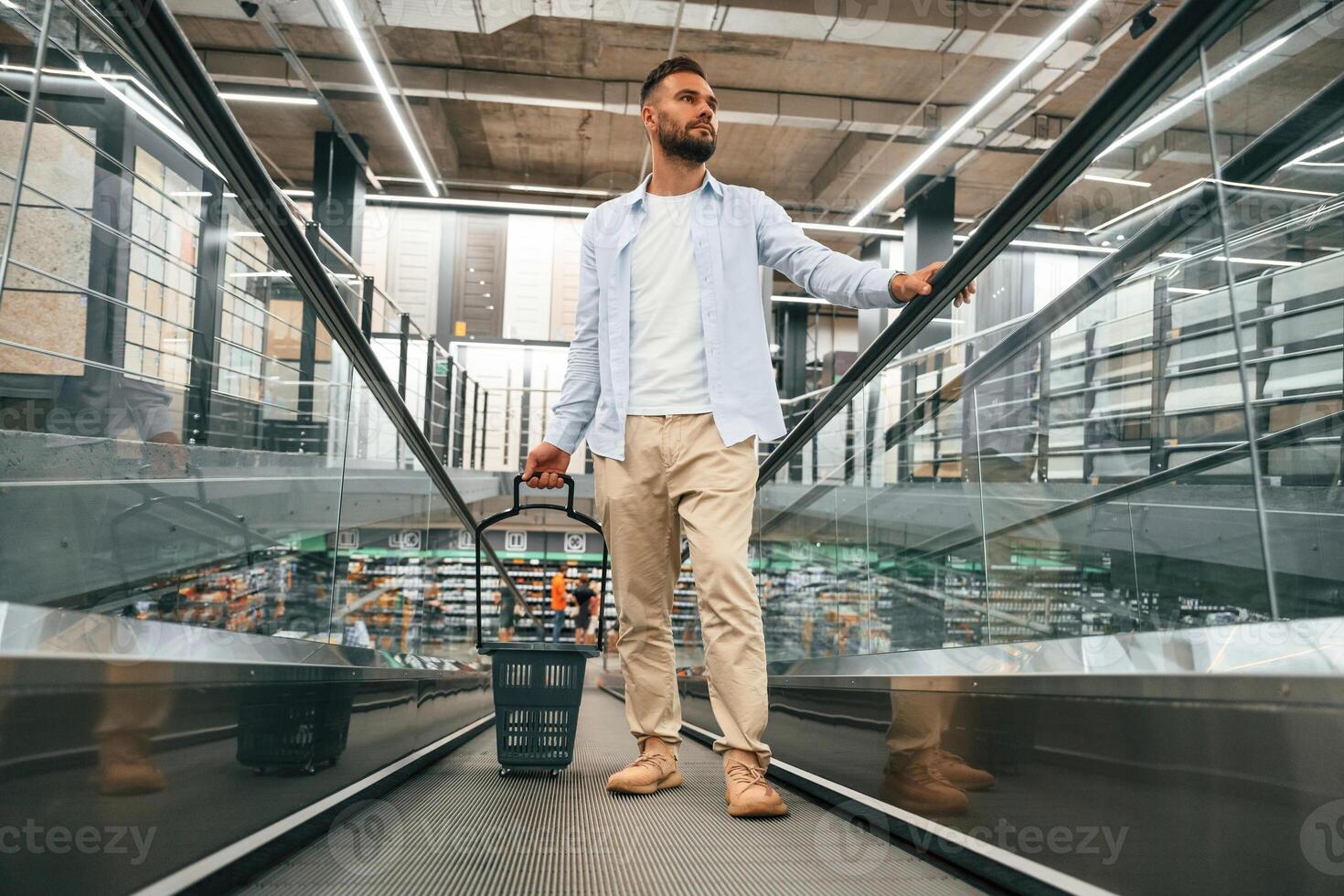 Customer is on the way. Handsome man ,,,is on the escalator in the mall photo