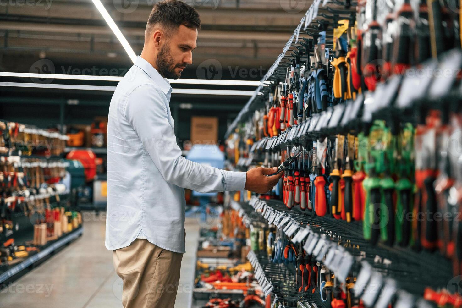 Searching, for,, the tools. Man is in the hardware shop photo