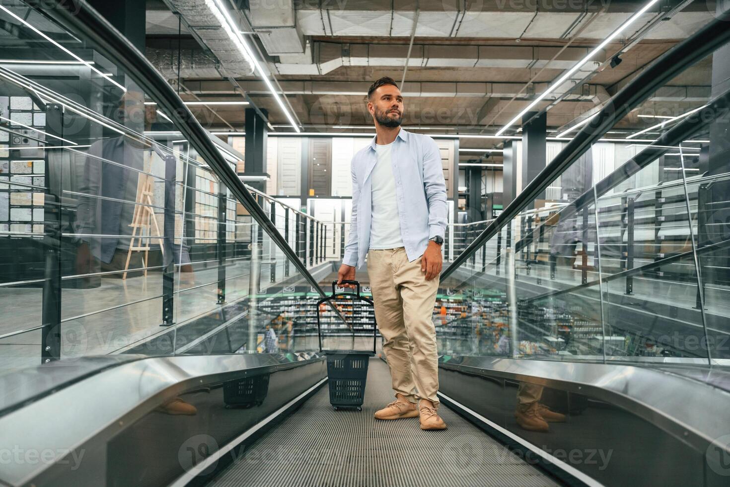 Front,, view. Handsome man is on the escalator in the mall photo