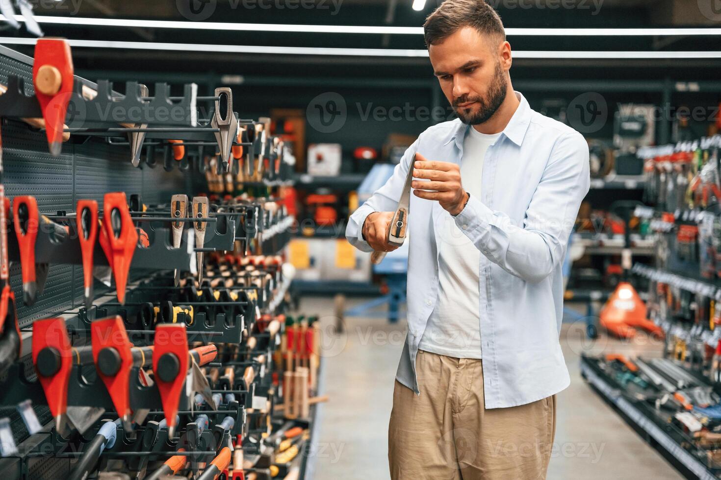 Picking an axe. Man, is ,in the hardware shop photo