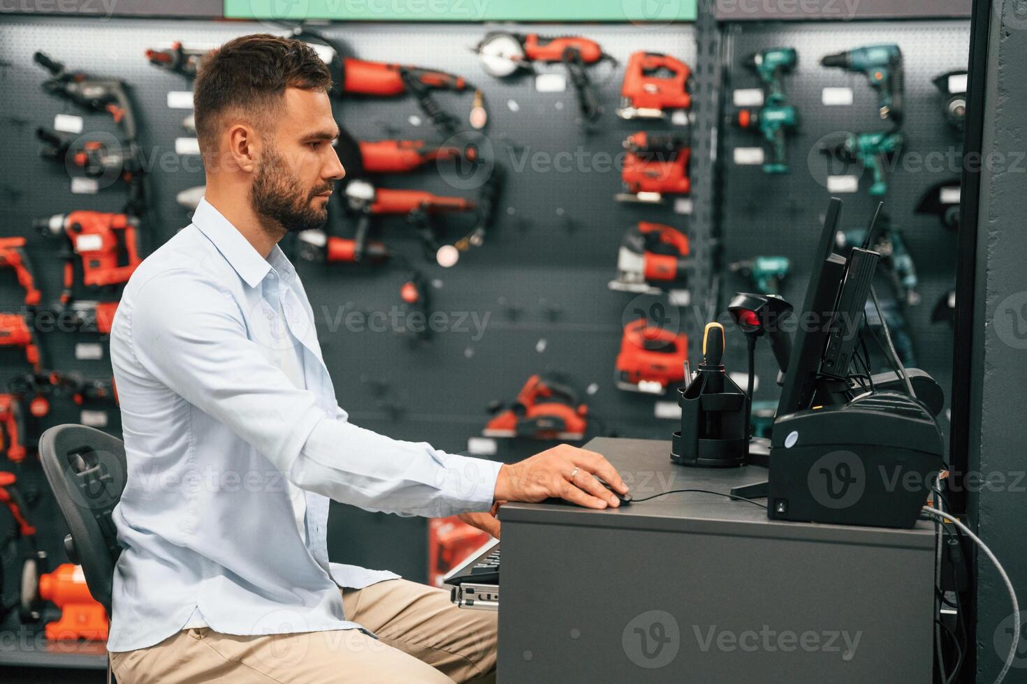 Cashier is, at,, work. Man is in the hardware shop photo