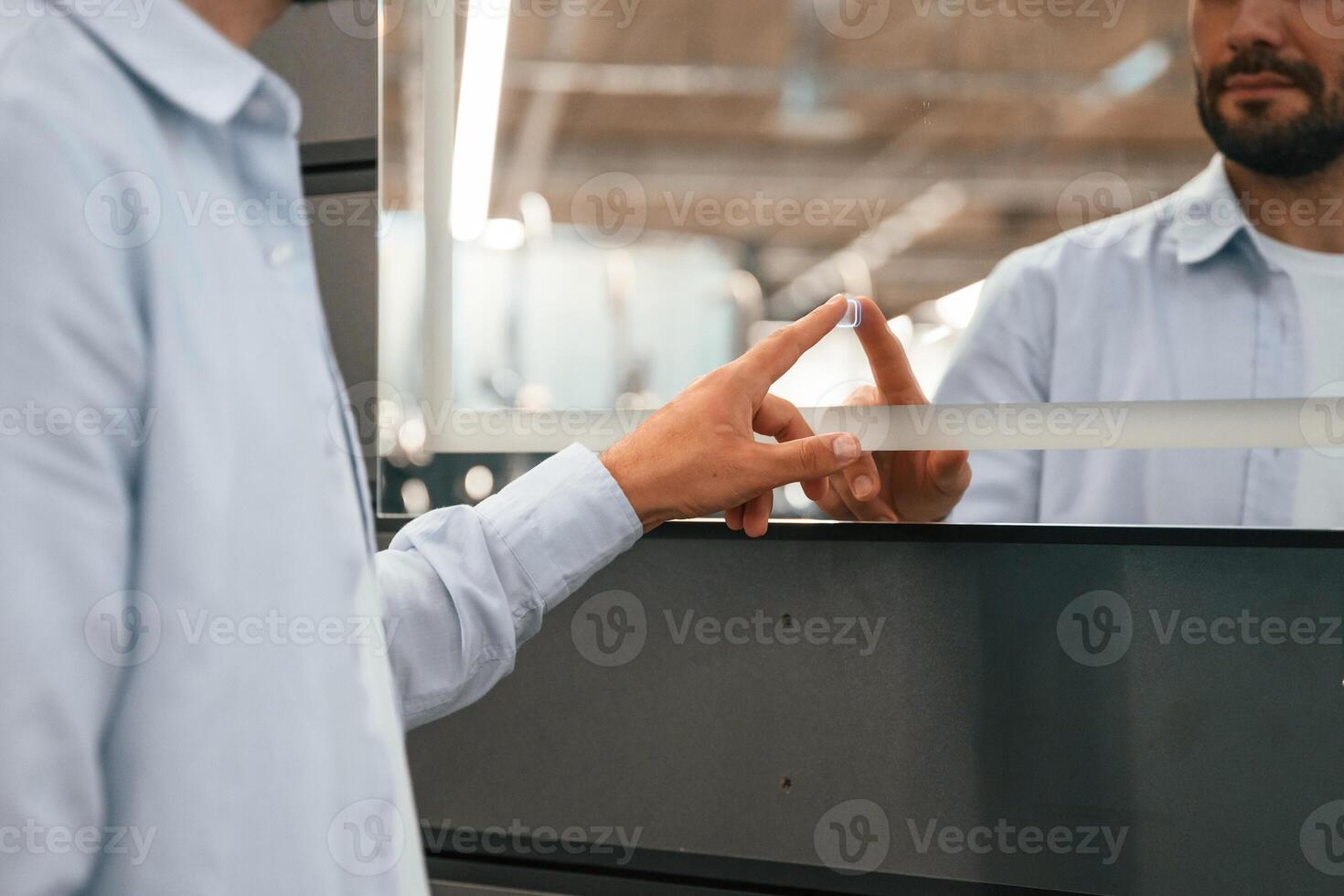 Touching, trying ,smart ,mirror. Man is in the hardware shop photo