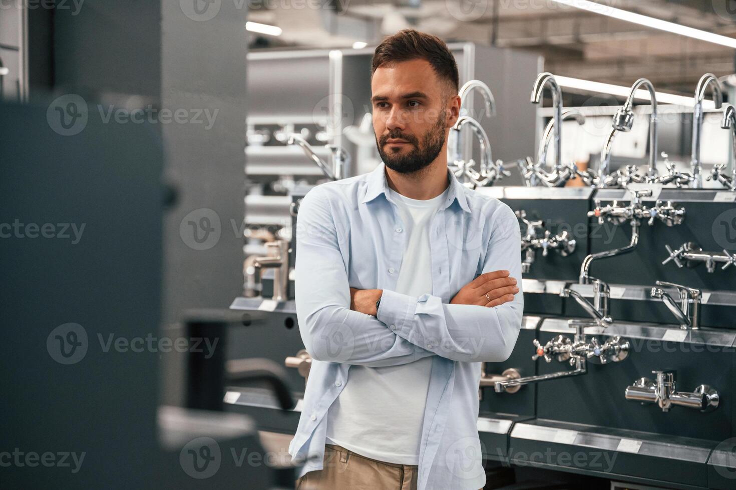 In a room, with plumbing, equipment. Man is in the hardware shop photo