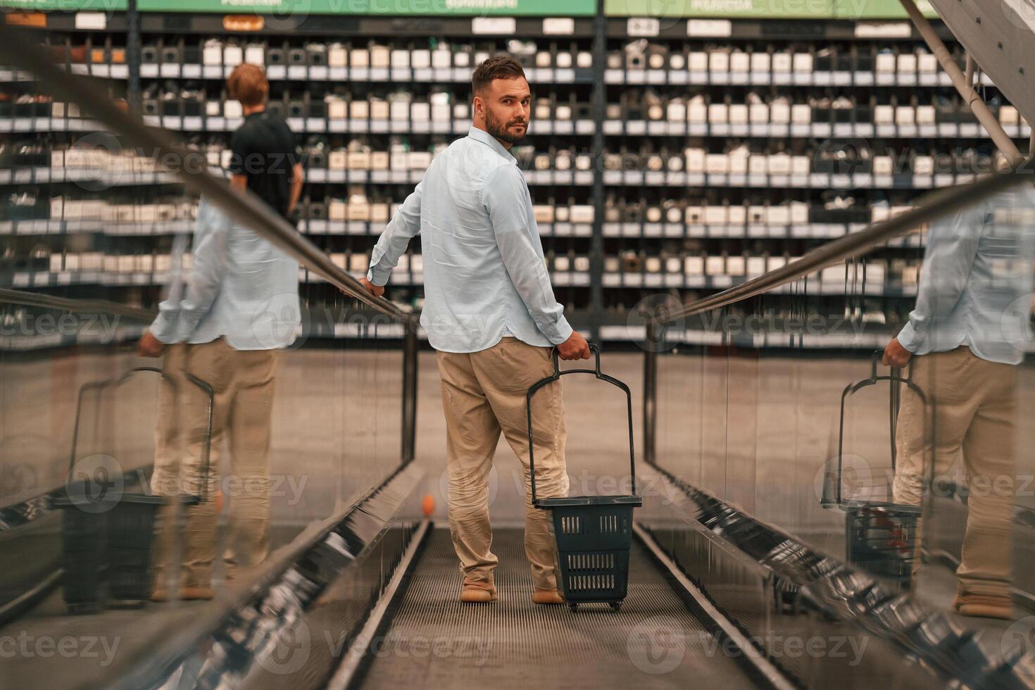 Customer is on, the, way. Handsome man is on the escalator in the mall photo