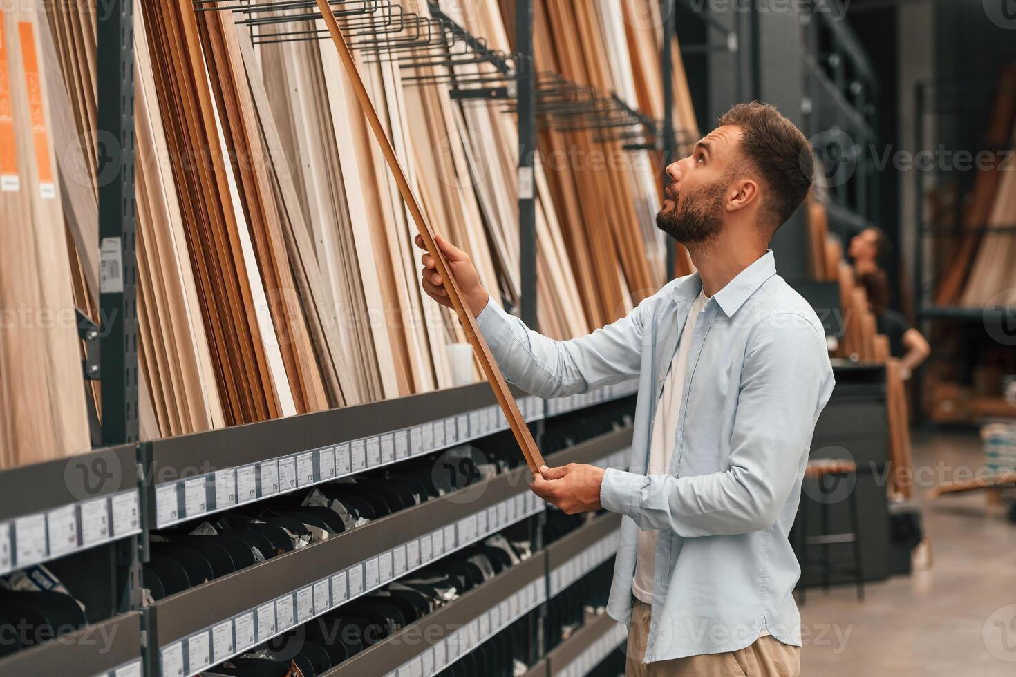 Warehouse ,with ,big choice of parquet. Man is in the hardware shop photo